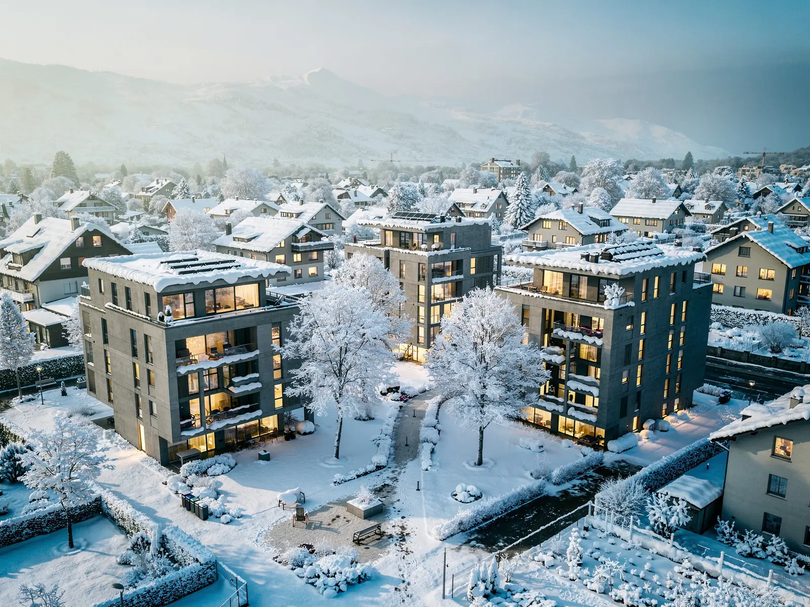 Drei moderne Schweizer Wohnbauten mit klaren Linien und autofreiem Aussenraum, Photovoltaik zurückversetzt auf den Dächern, im Winter