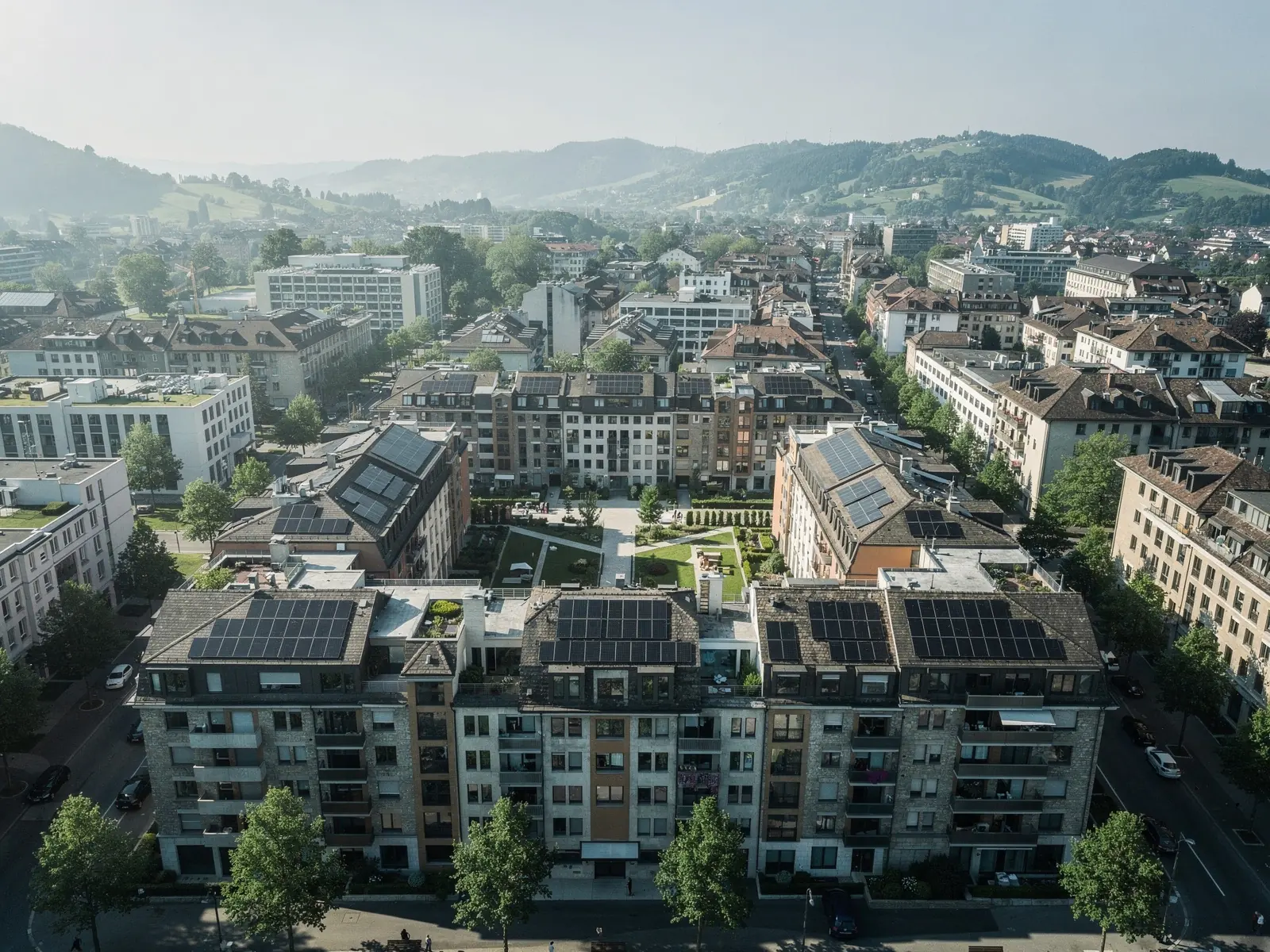 Luftaufnahme eines Schweizer Immobilienportfolios mit ruhiger Dachlandschaft und Photovoltaikanlagen